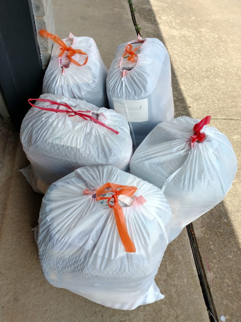 Photo of 5 white plastic bags full of packaged scarves